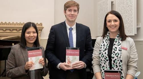 Teacher passing on love of poetry to pupils with book