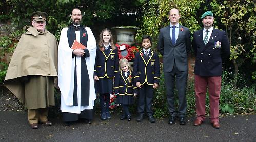 Children lay handmade wreaths at remembrance service in school grounds