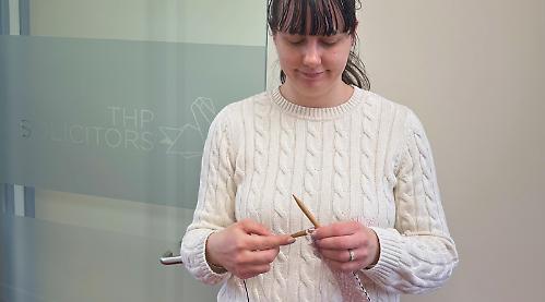 Woman knitting for charity in memory of footballer