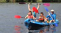 Families enjoy themselves on river before thunderstorm