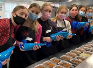 Sixth-form girls help provide meals for people in need