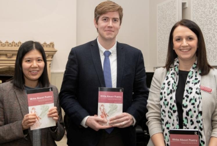 Teacher passing on love of poetry to pupils with book