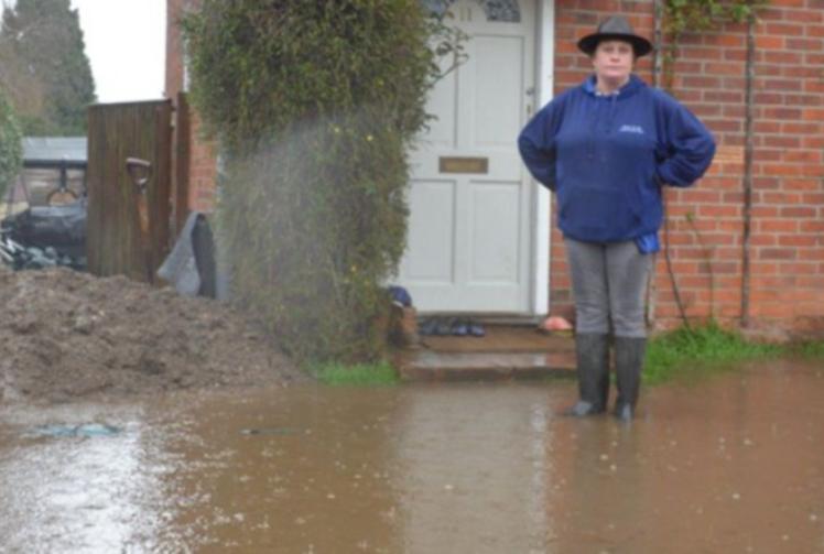 Woman blocks road with car to stop home flooding
