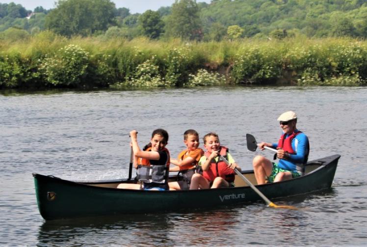 Families enjoy themselves on river before thunderstorm