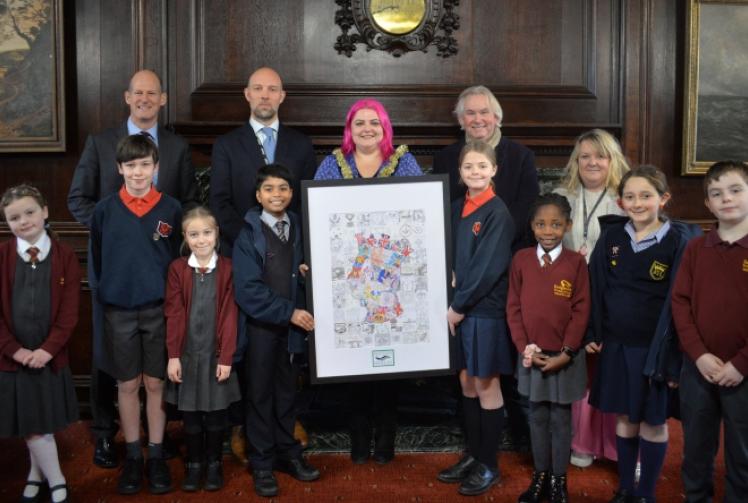 Children present their colourful portrait of King to town