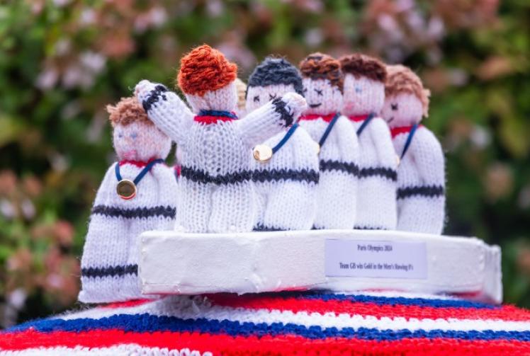 Knitted topper that captures cox’s gold medal celebration